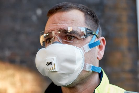 Man met veiligheidsbril en 3M Fijnstofmasker 8825+ dat zijn neus en mond bedekt